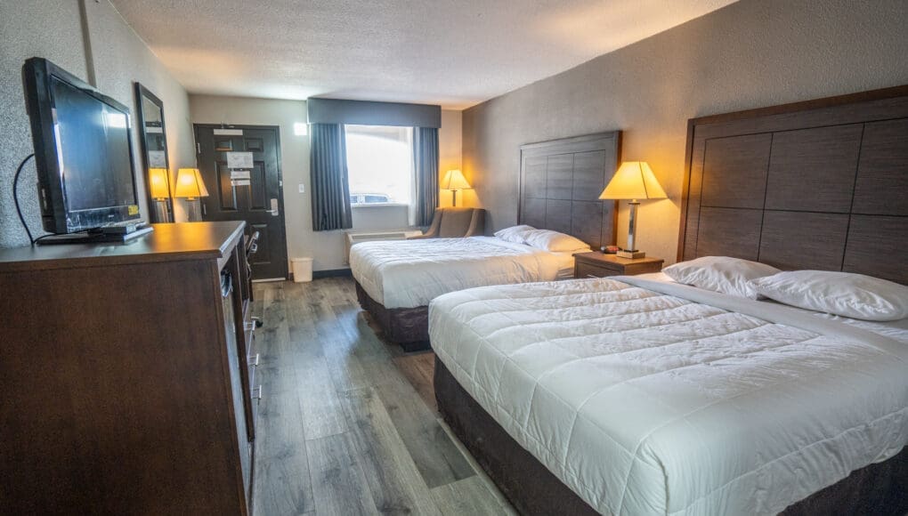 Double room in CHH Big Spring with a sitting area, a TV and night tables on each side of the beds