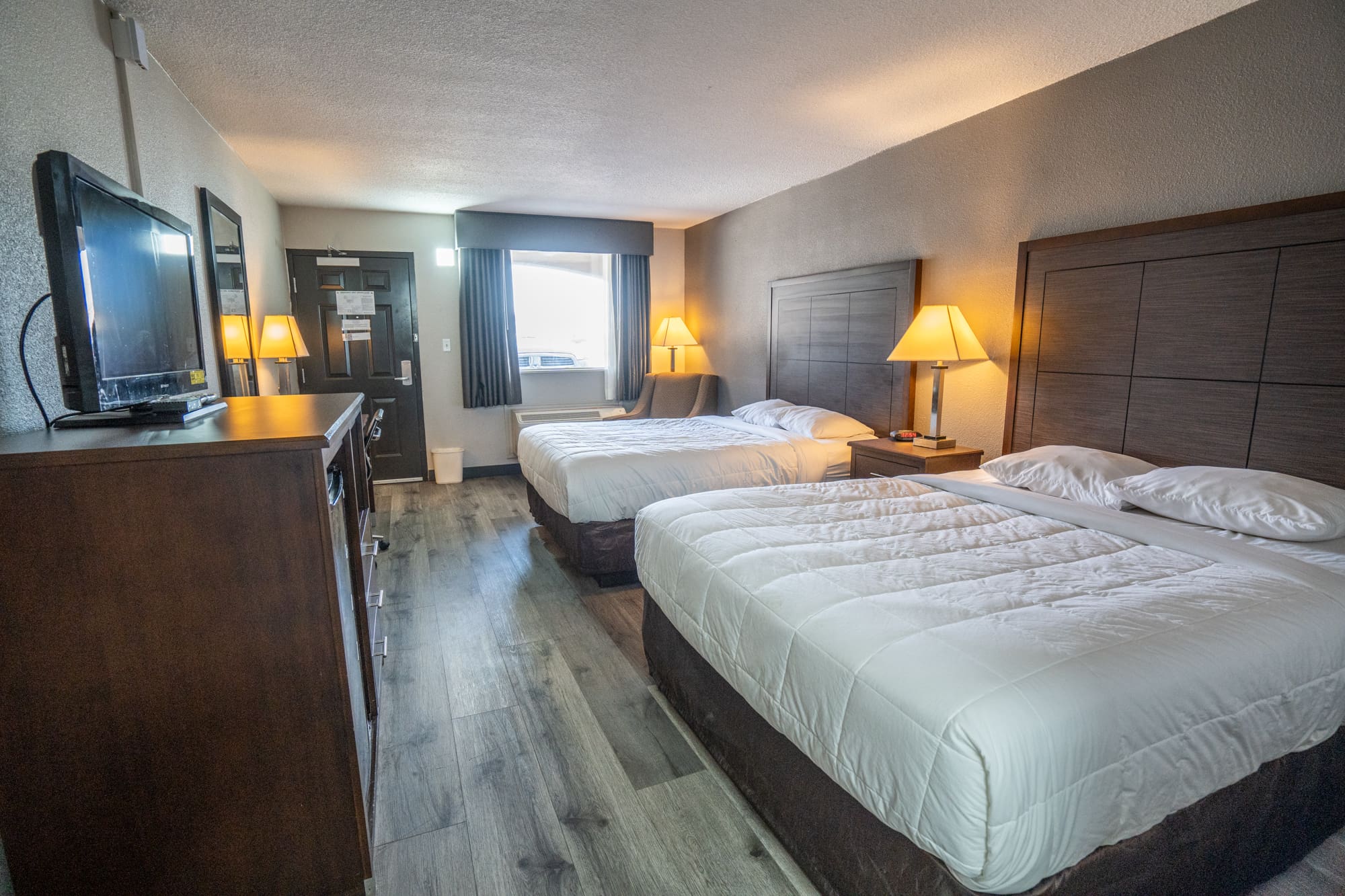 Double room in CHH Big Spring with a sitting area, a TV and night tables on each side of the beds